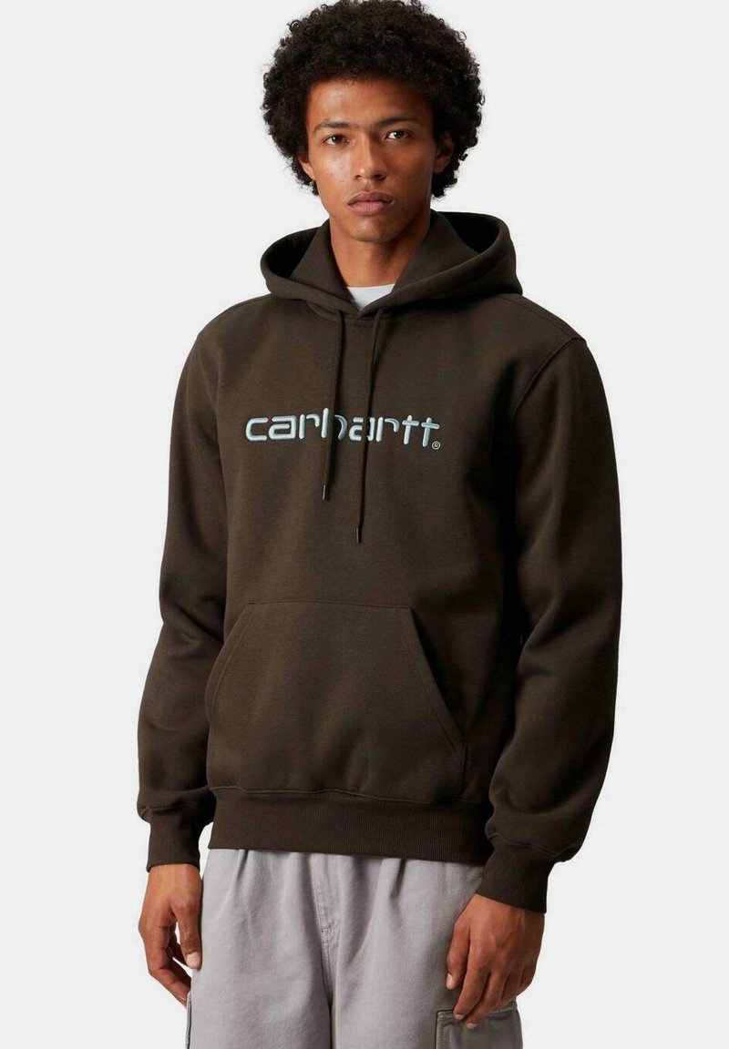 Sudadera marrón con bolsillo frontal, capucha con cordón ajustable y logo "carhartt" en azul claro. Fabricada con un tejido suave y de corte relajado.