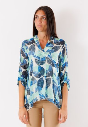 Blusa leggera e multicolore con stampa a foglie in tonalità di blu e verde; presenta un colletto a scollo a V e maniche arrotolabili.