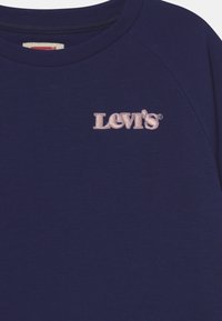 Felpa blu navy realizzata in tessuto morbido, con il logo ricamato rosa "Levi's" sul petto a sinistra e un colletto a costine.
