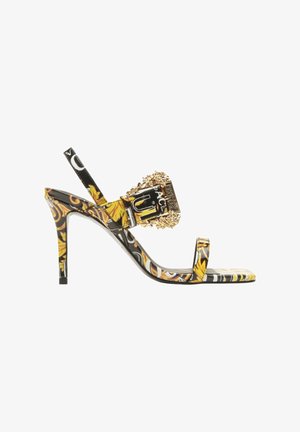 Sandale à talons hauts avec un dessus synthétique à motifs noir, jaune et blanc, dotée d'une boucle décorative en or et de fines lanières.