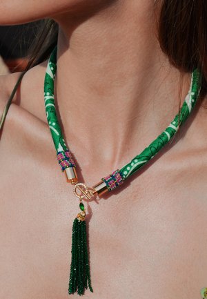 Choker en tissu vert avec un motif floral, accessoires en métal doré, embellissements en perles colorées et un pendentif à franges vert.