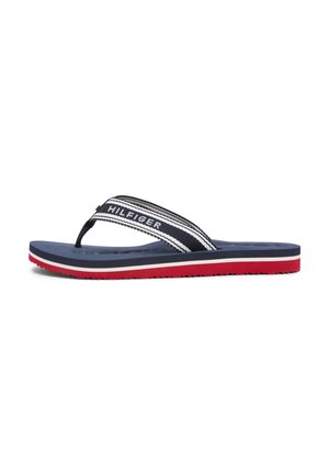 Navy flip-flop with striped fabric straps featuring the logo, a textured blue footbed, and a red outsole with a white trim.