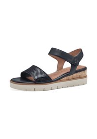 Schwarze Leder-Sandalen mit einem geflochtenen Textilriemen, Korkverzierungen, einer dicken weißen Sohle und einem verstellbaren Knöchelriemen.