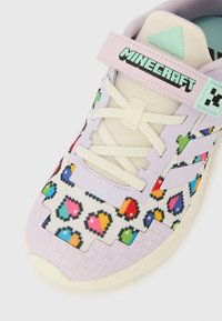 Παιδικό αθλητικό παπούτσι με εκρού �κορδόνια, πολύχρωμα μοτίβα καρδιάς σε pixel, λιλά επαλείψεις και ροζ λουράκι με την ένδειξη "Minecraft".