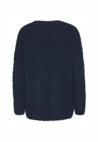 Tumši zils adīts džemperis ar teksturētu fuzzy apdari, ietilpīgs un ar garām piedurknēm, ar ribotu dizainu aizmugurē.