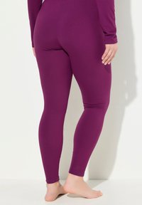 Paarse leggings van rekbaar, glad materiaal, met een aansluitend ontwerp en een enkellange snit, zonder opvallende patronen of hardware.