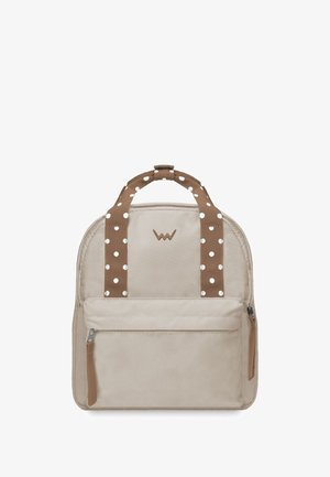 Beiger Stoffrucksack mit braunen Trägern mit Polka-Dot-Muster, abgerundetem Oberteil, vordere Reißverschlusstasche und einem dezenten Logo über dem Hauptreißverschluss.