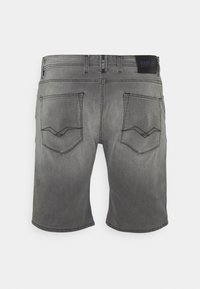 Pantalones cortos de mezclilla gris con un acabado desgastado, que cuentan con dos bolsillos traseros con patrones de costura distintos y una etiqueta de logo en la cintura.