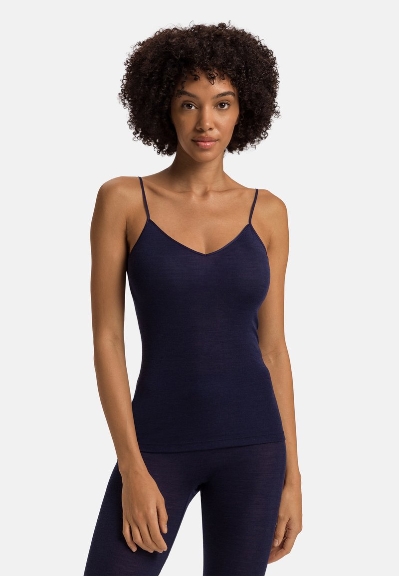 Námořnický modrý, přiléhavý top na ramínka s tenkými popruhy a výstřihem do V, vyrobený z jemného materiálu. Povrch vypadá hladce a pružně.
