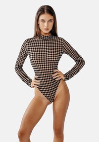 Bodysuit s dlouhým rukávem vyrobený z elastické látky, s černo-béžovým kostkovaným vzorem, vysokým límcem a vysokým vykrojením na nohách.