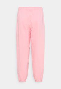 Pink jogger pants made of soft cotton material, featuring an elastic waistband and elastic cuffs at the ankles. Simple, casual design.
