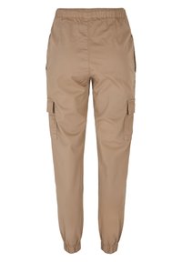 Kargo kalhoty ze světle hnědé tkaniny, s elastickým pasem a manžetami na kotnících, bočními kapsami a jednou funkcionalní kapsou na každé straně.