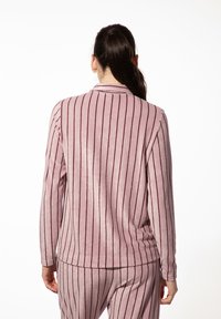 Roze gestreepte lange mouwtop van zacht, gestructureerd materiaal. Heeft verticale strepen in een donkere tint, met een kraag en een comfortabele pasvorm.