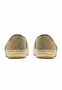 Paar olijfgroene canvas espadrilles met gevlochten jute zolen, gezien vanaf de achterkant op een witte achtergrond.