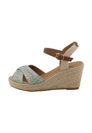Sandalia de cuña con plataforma de yute trenzado, tiras delanteras tejidas en verde claro y correa marrón en el tobillo con hebilla plateada.