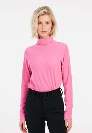 Rosa, eng anliegende, gerippte Rollkragensweiche mit langen Ärmeln, strukturierter Stoff, kombiniert mit schwarzen Hosen mit Gürtel.