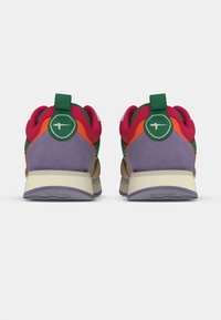 Paire de baskets colorées avec des panneaux violets, verts, orange et roses, vues de dos sur un fond blanc.