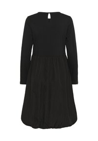 Crna haljina s dugim rukavima, uskim korzetom i lepršavom suknjom. Ima detalj s ključalom izrezom na leđima i teksturirani materijal.