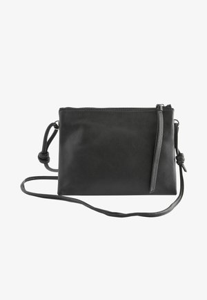 Black leather crossbody bag featuring a smooth texture, zip closure, long adjustable strap, and a knot detail on the strap.