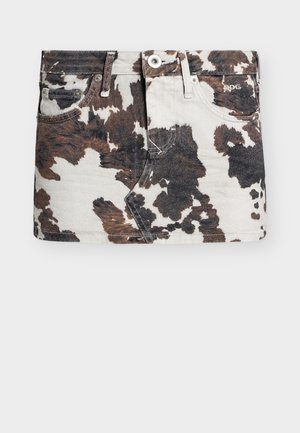 Jupe mini en denim avec un motif imprimé vache en noir, blanc et marron, dotée de poches à l'avant, de passants pour ceinture et d'une fermeture par bouton.