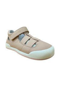 Zapato de cuero marrón claro con dos correas de Velcro. Presenta cortes para una mayor transpirabilidad, una suela de goma blanca y textura antideslizante.