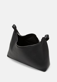 Svart läderväska med en slät, texturerad yta, vid öppning och dragkedja som stängning. Har två handtag på vardera sidan.