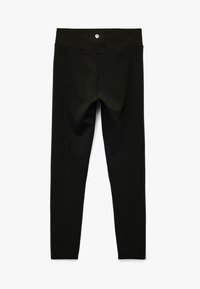 Zwarte leggings met een hoge tailleband, gemaakt van een gladde, rekbare stof. Kenmerkt zich door minimale stiksels en een klein logo op de achterkant.
