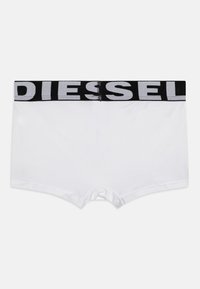 Vita bomullboxershorts med en svart elastisk midjeband som har vit "DIESEL" text. Designen är enkel och strömlinjeformad.