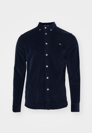 Camicia in velluto a coste blu navy con colletto button-down, bottoni frontali, maniche lunghe e un piccolo logo ricamato sul petto.