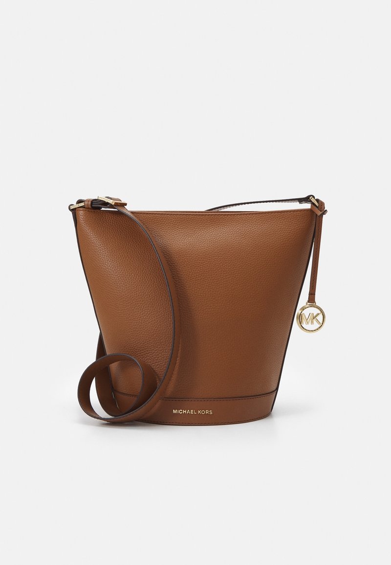 Sac seau en cuir marron avec bandoulière ajustable, breloque avec logo Michael Kors en or et nom de la marque embossé en bas.