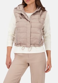Leichte, beige Pufferweste mit Kapuze, seitlichen Reißverschlüssen und verstellbarem Kordelzugsaum. Strukturierte Stepp-Oberfläche über die gesamte Weste.