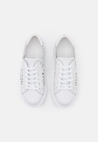 Białe sneakersy z gładką skórzaną cholewką, sznurowanym zapięciem oraz perforowanymi akcentami po bokach, które zapewniają wentylację i detale.
