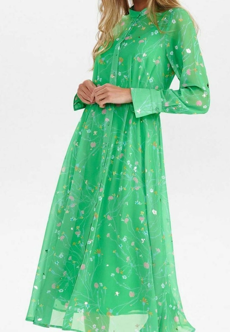 Lång grön klänning gjord av genomskinlig tyg, med ett blommönster i rosa, vitt och gult, med knapplås framtill och långa ärmar.