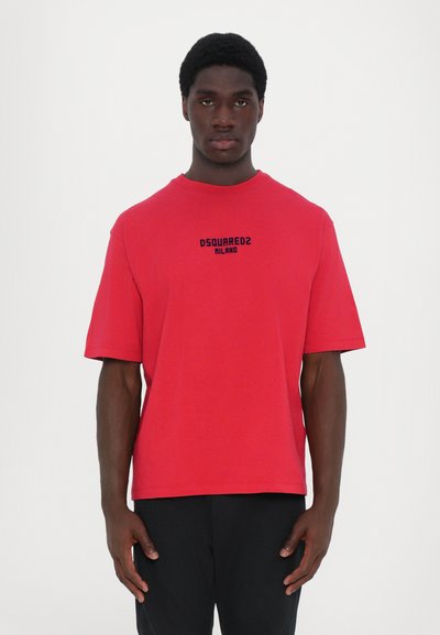 Maglietta rossa in cotone con maniche corte e collo tondo, con la scritta "DSQUARED2 MILANO" stampata in nero sul fronte.