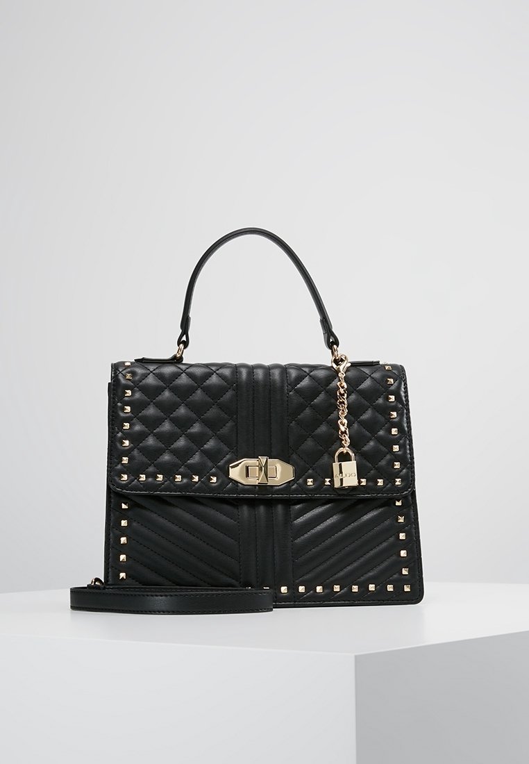 Svart quiltad läderhandväska med hardware i guldton, nitar, handtag på toppen, avtagbar axelrem och hänglåsdetalj.