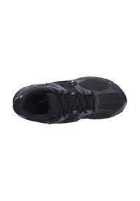 Chaussure de sport noire avec tige en mesh et synthétique, bout arrondi, fermeture à lacets et semelle en caoutchouc texturée avec un design de soutien.