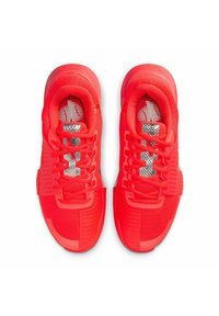 Paar leuchtend roter Sportschuhe mit Schnürsenkeln und silbernen reflektierenden Zungenpatches, von oben auf weißem Hintergrund gezeigt.