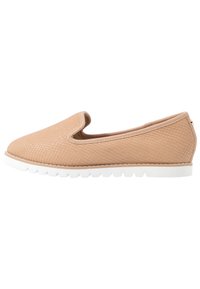 Scarpa slip-on in materiale texturizzato marrone chiaro, con suola in gomma bianca e punta rotonda. Nessun hardware o accenti visibili.