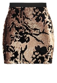 Minifalda negra cubierta de lentejuelas doradas que forman un patrón floral abstracto, con una cinturilla negra sólida.