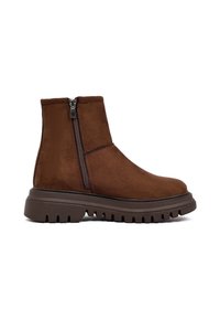 Bruine suède enkelboot met een zijrits, chunky rubberen zool en gestructureerde afwerking. Strak ontwerp met een ronde neus en minimale details.