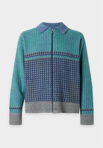 Pull à manches longues zippé avec col bleu, motif à carreaux vert et marine, et poignets et ourlet côtelés gris sur fond blanc.