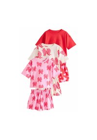 Tre set di abbigliamento per bambini con t-shirt a maniche corte e pantaloni corti. I colori includono rosso, rosa e crema con motivi a fiocco e cuori.
