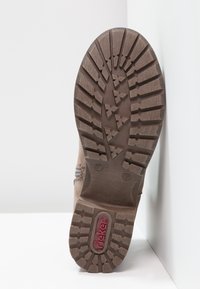 Semelle de botte marron avec des motifs de profondeur, marquage de taille 37 et logo rouge "rieker" sur la zone du talon, sur fond blanc.