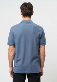 Pánska polokošeľa svetlomodrej farby, s krátkym rukávom a textúrovanou látkou. Má klasický golier a rovný lem, minimalistický dizajn.