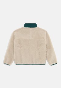 Fleecepullover i kräm med en tealfärgad krage; har en texturerad, fluffig tyg och ribbade ärmslut. Bakvy visar en enkel, ren design.