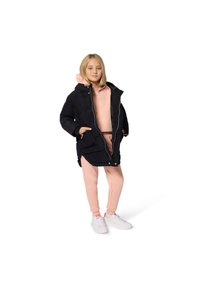 Svart polstret parkasjakke med hette, kombinert med en rosa hettegenser og matchende joggebukser. Hvite joggesko fullfører antrekket.