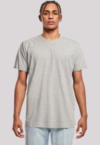 Šedé tričko s krátkým rukávem a kulatým výstřihem, vyrobené z jemného materiálu. Rovný střih, minimalistický design, bez viditelných vzorů nebo akcentů.