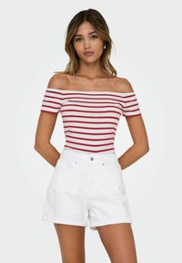 Röd och vit randig off-shoulder topp kombinerad med uppvikta vita denimshorts. Har en snug passform och mjukt, lätt tyger.