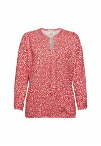 Blusa rossa a maniche lunghe con motivo floreale che presenta fiori bianchi e blu, apertura con bottoni sul davanti e scollatura a V con arricciature alle spalle.