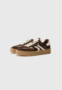 Sneaker in suede e satin marrone con accenti e lacci crema. Presentano una suola in gomma e elementi di design sovrapposti.